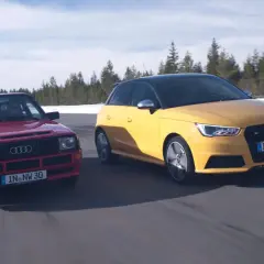 Dwa Audi S1 Quattro, czerwony klasyk i żółty współczesny, pędzą po drodze wśród zimowych krajobrazów.