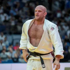 Marcus Nyman, en svensk judoka, står på mattan i sin vita dräkt med svart bälte. Publiken syns i bakgrunden.