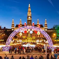 Wiedeński jarmark bożonarodzeniowy tętni życiem pod ratuszem. Kolorowe iluminacje, choinka i tłumy ludzi tworzą magiczną atmosferę.