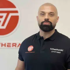 Tomasz Chachurski w czarnej koszulce z logo Toonytherapy, na tle białej ściany.