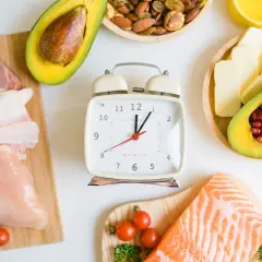 Zegar tyka, wskazując czas na dietę if. Mięso, ryby, awokado i orzechy czekają na zdrowe posiłki.