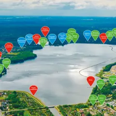 Widok z lotu ptaka na Jezioro Rybnickie z zaznaczonymi atrakcjami: plaże, restauracje, przystanie, tor rowerowy i skatepark.