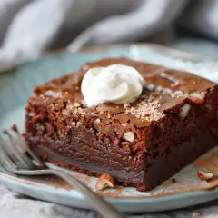 En saftig brownie med hasselnötter, toppad med vispad grädde. Perfekt för ett gott fudge brownie recept.