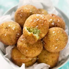 Deliziose polpette di zucchine e ricotta, dorate e croccanti, cosparse di sale grosso.