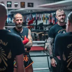 Tränare och fighters i en ring, alla bär tröjor med texten "onechai muaythai".