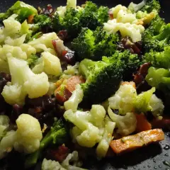 Un panache de verduras salteadas en sartén, con brócoli, coliflor y zanahoria, listo para disfrutar.