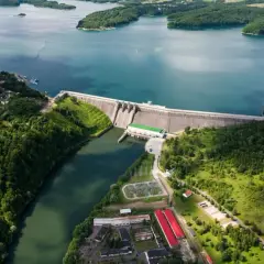 Widok z lotu ptaka na zaporę wodną w Solinie, jezioro i otaczające ją zielone wzgórza.
