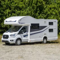 Nowy biały kamper z niebieskimi akcentami, idealny na wakacje. Sprawdź ofertę camper wypozyczenie.