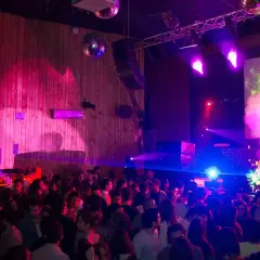 Festa al Macarena Club Barcelona, con luci stroboscopiche, DJ e fuochi d'artificio sullo schermo.