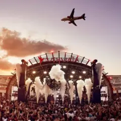 Niesamowite ibiza imprezy pod niebem z samolotem! Tłum szaleje na koncercie, a scena rozświetlona jest światłami i dymem.