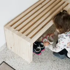 Dziecko układa buty na prostej ławce z drewna. Dowiedz się, jak wykonać prostą ławkę, która pomieści obuwie.