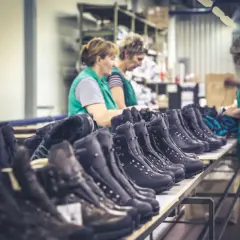 Workers inspect rows of Hanwag boots, hinting at where Hanwag boots are made: a factory floor.