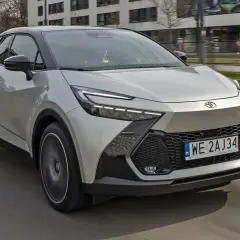Nowa Toyota C-HR w kolorze srebrnym pędzi po mieście. Zastanawiasz się, ile kosztuje nowa Toyota C-HR? Ten stylowy crossover zachwyca designem.