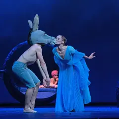 Na scenie, w niebieskim świetle, tancerz w masce osła całuje tancerkę w błękitnej sukni. To magiczny "Sen nocy letniej spektakl".