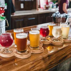 Bierverkostung mit verschiedenen Sorten in Gläsern auf Holztabletts. Perfekte trinktemperatur für jedes Bier.