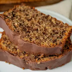 Zwei Scheiben saftiger **Schoko Nuss Kuchen** mit Schokoladenglasur auf einem Teller.