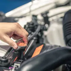 Dłoń odkręca korek chłodnicy samochodu Hyundai i30.