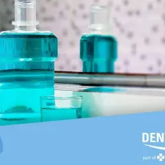 Flaconi di collutorio azzurro e un bicchierino con il liquido. Ricorda che il collutorio va risciacquato per una corretta igiene orale.