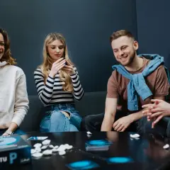 Grupa przyjaciół śmieje się, grając w grę słowną "Po Prostu P".