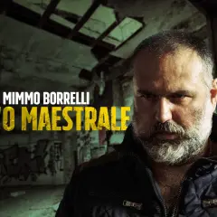 Mimmo Borrelli, 'O Maestrale, in un'ambientazione che ricorda Gomorra, con graffiti e un'atmosfera cupa.