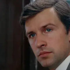 Zbliżenie na twarz mężczyzny w szarym garniturze, z niebieskimi oczami. Scena przypomina ujęcia z filmu "Znachor", gdzie był kręcony.