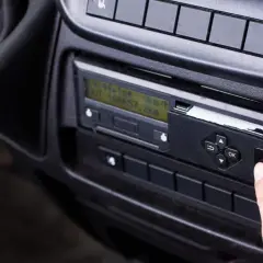 Palec naciska przycisk na tachografie, który zapisuje dane o tym, ile dni zapisuje karta kierowcy.
