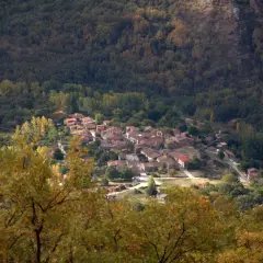 Un pueblo de tejados rojos se asoma entre la arboleda otoñal. La acebeda, un lugar tranquilo rodeado de naturaleza.