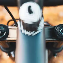 Close-up of a RockShox Pike fork's top caps, showing the "AIR" and "CHARGER 3" adjustments. The weight of this fork is a key factor for trail riders.