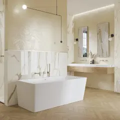 Elegancka łazienka ze złotymi dodatkami. Marmurowe płytki, wolnostojąca wanna i drewniana podłoga tworzą luksusową atmosferę.