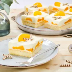 Saftiger Mandarinen Schmand Kuchen Blech, dekoriert mit Mandarinenstücken und Schokoröllchen. Ein Genuss für Augen und Gaumen!