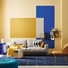 Modernes wohnzimmer blau gelb: graues Sofa, gelbe Decke, blaue Akzente und geometrische Muster auf dem Teppich.