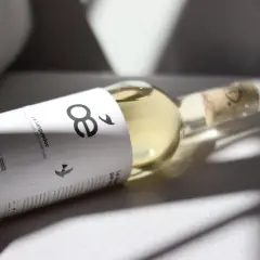 Flasche mit hellem Wein, Etikett mit "8" und Vögeln, Bio-Siegel. Ein Wein ohne Sulfite, der die Natur ehrt.