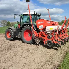 Zielony traktor z siewnikiem Gaspardo na polu. Idealny czas, by zasiać kukurydzę i cieszyć się plonami.