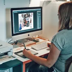Une graphiste textile travaille sur son ordinateur, créant des moodboards et des designs. Une imprimante est visible à côté.
