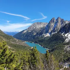 Lago turquesa rodeado de bosques y montañas nevadas, un paisaje espectacular cerca de Esterri d'Àneu.