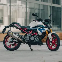 Biało-niebieski motocykl BMW G310R z czerwonymi felgami i wydechem Akrapovič. Poznaj jego bmw g310r dane techniczne.