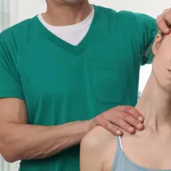 Osteopata delikatnie masuje kark kobiety, pomagając jej odzyskać komfort.