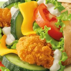 McWrap Bekon Deluxe: chrupiący kurczak, bekon, ser, warzywa i sos w tortilli. Pyszny i sycący, idealny na szybki posiłek.