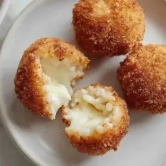 Croquettes de riz italiennes dorées et croustillantes, une bouchée révèle un cœur fondant. Parfaites pour une recette facile.