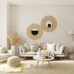 Przytulny salon w stylu minimalizm. Jasna kanapa, fotel, okrągłe lustra i plecione dodatki tworzą ciepłą atmosferę.