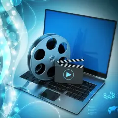 Laptop z kliszą filmową i klapsem, symbolizujące odtwarzanie multimediów. Idealne do obsługi plików dzięki K-Lite Codec Pack.