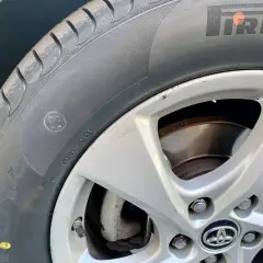 Un neumático Pirelli con un punto amarillo, marca de fábrica, y un pequeño círculo con una cara sonriente en el flanco.