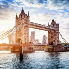 Tower Bridge w Londynie o zachodzie słońca, z nowoczesnymi wieżowcami w tle.