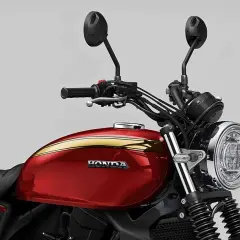 Detalle de la Honda GB 750, con su tanque rojo brillante y detalles dorados, lista para la aventura.