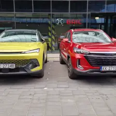 Dwa nowe chińskie samochody, żółty i czerwony, zaparkowane przed salonem BAIC w Europie.