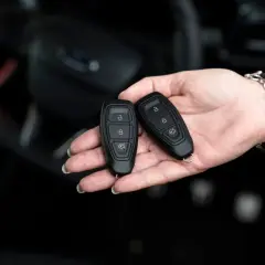 Dwie karty do kluczyka samochodowego w dłoni. Zastanawiasz się, keyless entry co to? To wygoda bez kluczyka.