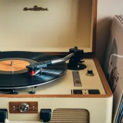 Retro gramofon z płytą winylową i stosem okładek. To jak pierwszy gramofon, który przywraca wspomnienia.