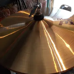 Błyszczące, złote talerze Paiste FX, instrument perkusyjny, odbijają światło, gotowe do rytmicznego uderzenia.