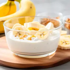Bananowy jogurt z plasterkami banana i suszonymi owocami. Idealny na białą dietę.