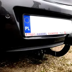 Widok z tyłu samochodu Opel Insignia z zamontowanym modułem haka. Widoczna tablica rejestracyjna i czujnik parkowania.